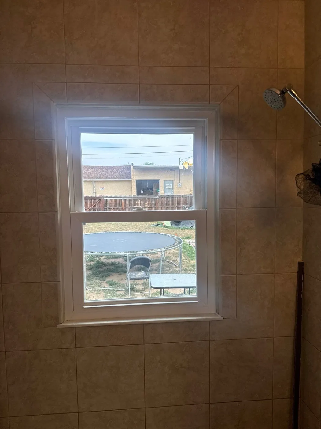 New double-hung window installed in a tiled bathroom wall